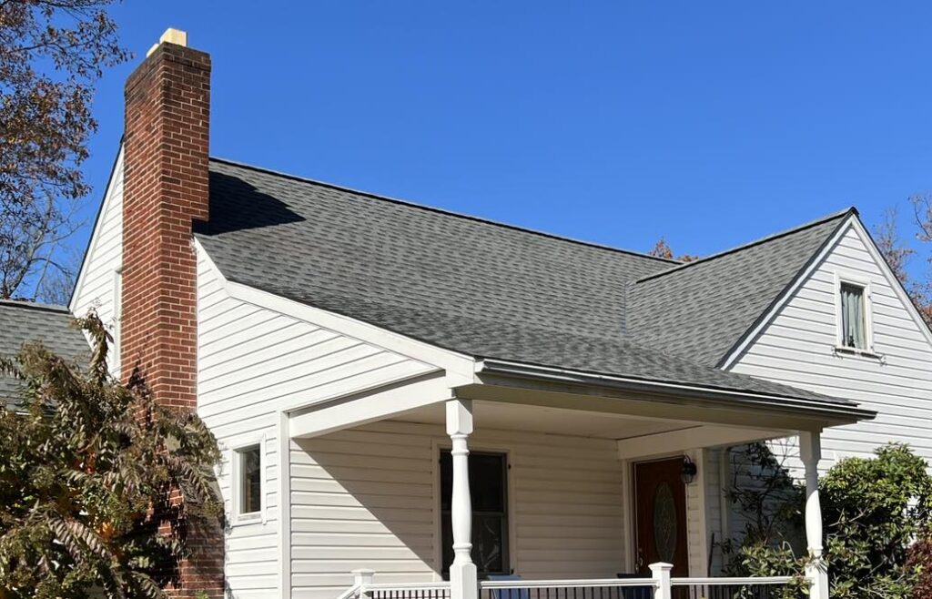 White house with gray roof and brick chimney
