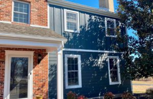 Brick and blue house exterior with windows.
