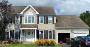 Two-story suburban house with garage and flowers.