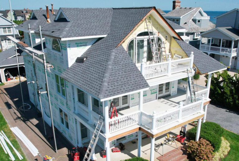 Large house undergoing exterior renovation with scaffolding.