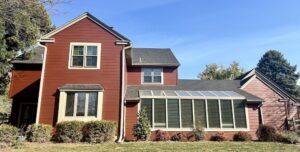 A Red house with large windows and clear sky.