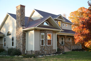 Modern house with stone chimney, autumn trees