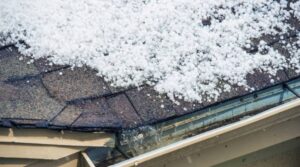 Hail covering a dark roof during a winter storm.