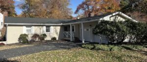 A single-story Pennsylvania house topped with a new roof and surrounded by autumn foliage.