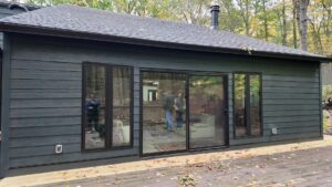 Modern house with glass sliding doors in the woods.