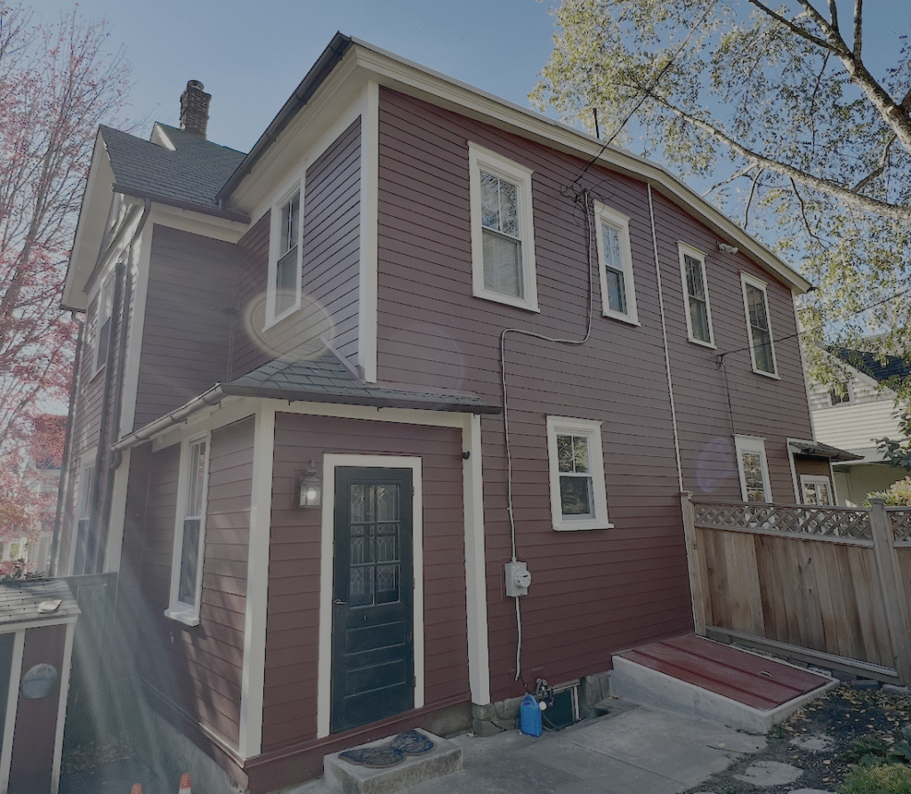 Two-story red house with multiple windows.