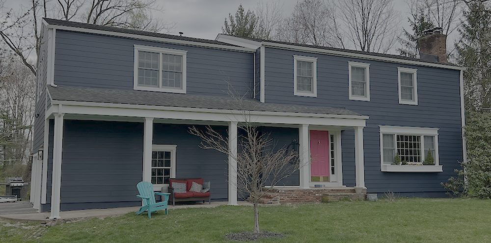 Blue two-story home with white trim and a bright front door.