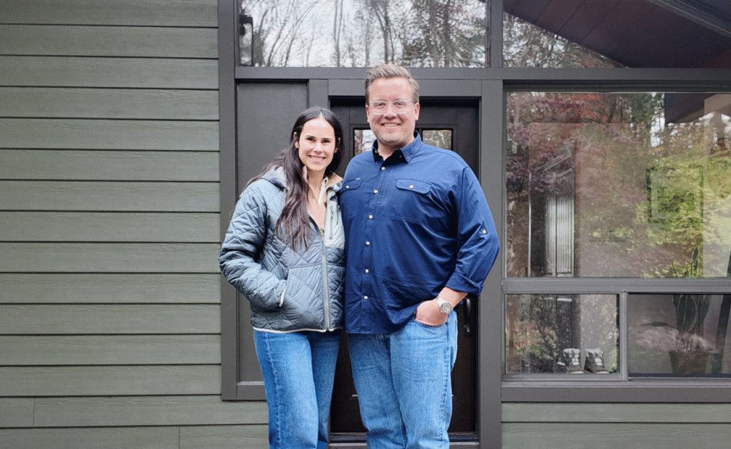 Couple smiling in front of a modern house