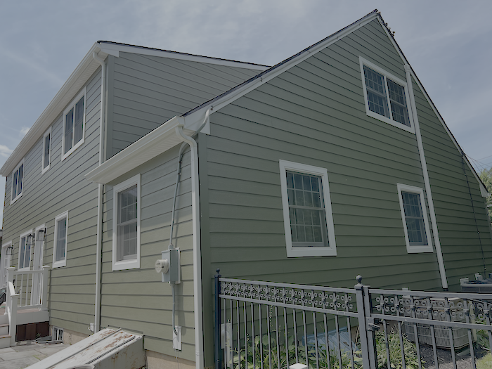 Green James Hardie Hardie Plank siding with white trim and windows in Yardey, PA.