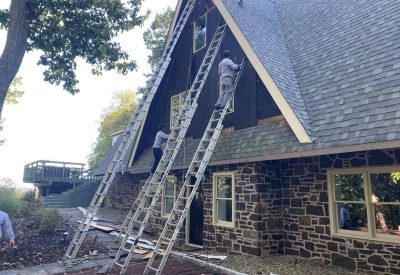 Installing new windows and siding on a house during renovation project.