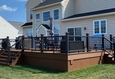 Deck installation in Collegeville, PA showcasing a durable wooden deck with black railings. Expert c.