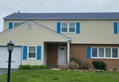House with new siding and blue shutters in Trooper PA.